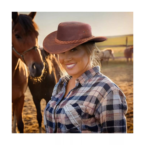 Woman wearing Equiencares genuine leather cowboy hat while standing near horses in rustic outdoor setting